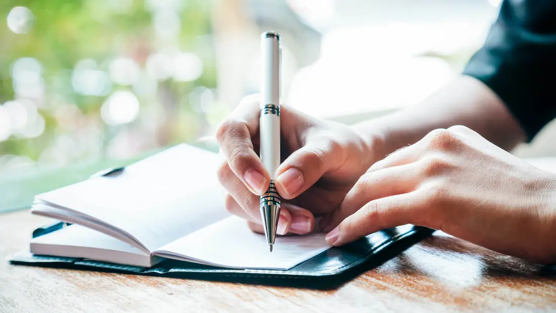 کسی که در یک دفترچه می‌نویسد